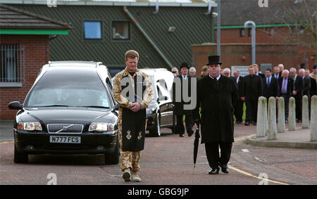 An Army Chaplin (name not known) walks in front of the coffins of sappers Patrick Azimkar and Mark Quinsey leave Massareene Barracks in Antrim, Northern Ireland. Stock Photo