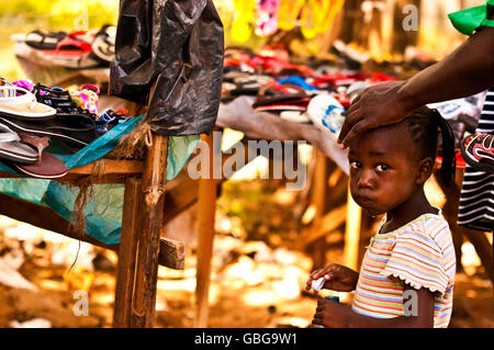 MASAI MARA, KENYA. DECEMBER 18, 2011: A young Kenyan girl at a market with her mother in Mombassa, Kenya. Stock Photo