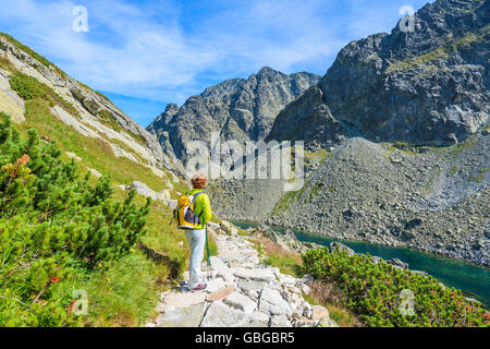 Young woman backpacker on hiking trail in summer landscape of High Tatra Mountains, Slovakia Stock Photo