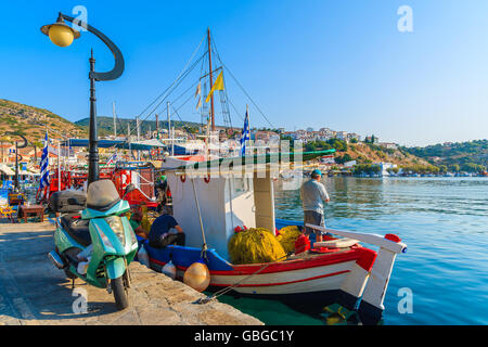 PYTHAGORION PORT, SAMOS ISLAND - SEP 19, 2015: fisherman standing on a boat in beautiful Pythagorion port on Samos island, Greec Stock Photo