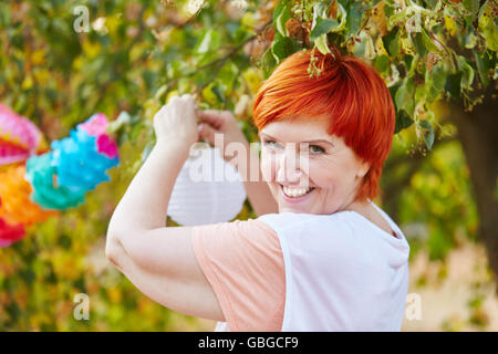 Senior woman decorating for a party in the park Stock Photo