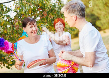 Seniors decorating for a summer birthday party in the park Stock Photo