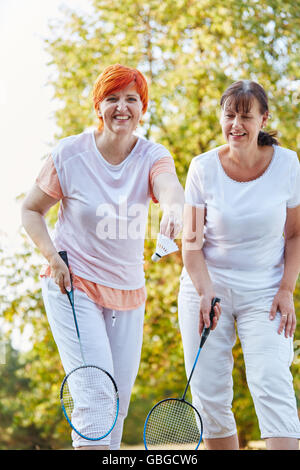 Two women playing badminton in the nature having fun Stock Photo