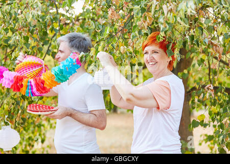 Seniors decorating for a summer party in the park Stock Photo