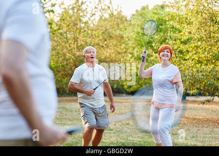 Active seniors playing badminton in the park in summer Stock Photo