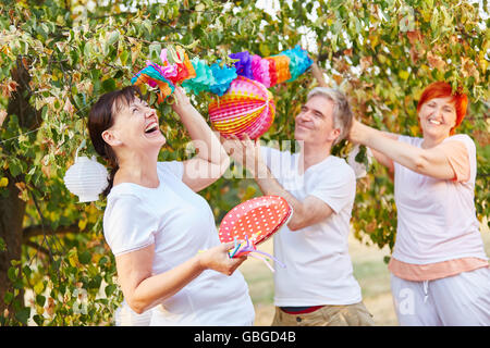 Seniors laughing and having fun while decorating for a birthday party in the park Stock Photo