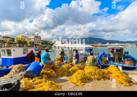 SAMOS ISLAND, GREECE - SEP 23, 2015: fisherman repairing nets in port on sunny afternoon. Greek islands are famous for tradition Stock Photo