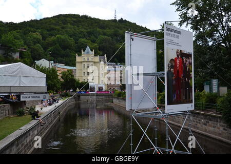 KARLOVY VARY, CZECH REPUBLIC - JULY 3: People walk on streets of spa town Karlovy Vary with roof of Hotel Thermal in foreground Stock Photo