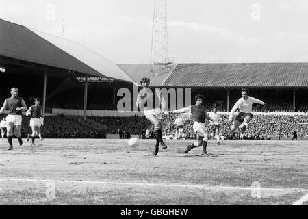 Tottenham Hotspur's Jimmy Greaves (r) shoots towards goal. Also pictured is West Ham United's Bobby Moore (far left)and Billy Bonds (centre). Later in the match the two players linked arms and performed an impromptu dance on the pitch. Stock Photo