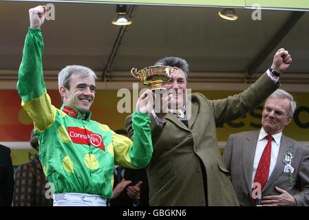 Winning Jockey Ruby Walsh (left) and Trainer Paul Nicholls celebrate with the trophy after Kauto Star wins the Totesport Cheltenham Gold Cup Chase. Stock Photo