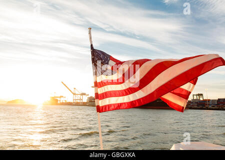 American Flag waves in the wind of back of ship in San Francisco Bay Stock Photo