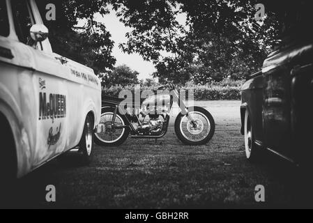 1970 Triumph TR6 motorcycle and american pick up trucks at Malle, The Mile Racing event. London . Vintage monochrome filter Stock Photo