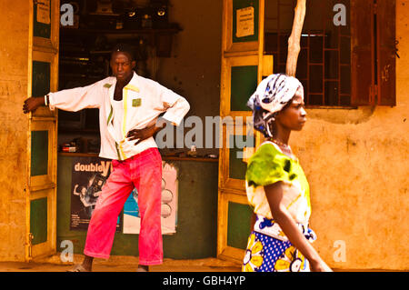 MASAI MARA, KENYA. DECEMBER 18, 2011: A Kenyan man in pink trousers stands in the doorway of his shop in Mombassa. Stock Photo