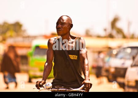 MOMBASSA, KENYA. DECEMBER 18, 2011: A lean Kenyan man rides his push bike through the streets of Mombassa, Kenya. Stock Photo