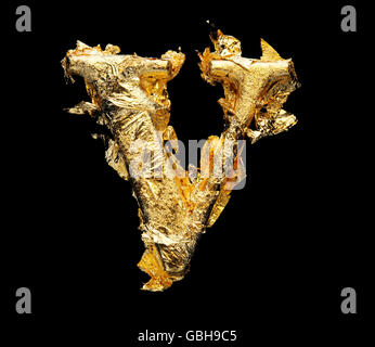 Alphabet and numbers in rough gold leaf isolated on black Stock Photo