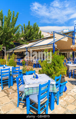 SAMOS ISLAND, GREECE - SEP 24, 2015: tables with blue chairs in traditional Greek tavern in Pythagorion town on coast of Samos i Stock Photo