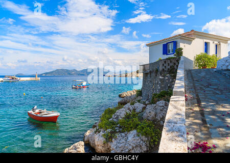 Typical Greek house and fishing boat in Kokkari bay on coast of Samos island, Greece Stock Photo