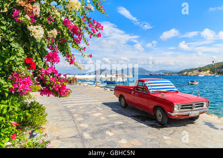 KOKKARI PORT, SAMOS ISLAND - SEP 24, 2015: Classic red pickup car parked on shore in Kokkari village, Samos island, Greece Stock Photo