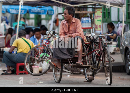 YANGON, MYANMAR - JANUARY 2, 2016: Unidentified trishaw driver on a break on the streets of Yangon , Myanmar on January 2, 2016. Stock Photo