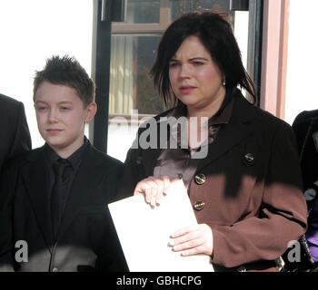 Sharon Mills, 34, the mother of Mason Jones, 5, from Deri, near Bargoed, South Wales, who died at Bristol Royal Hospital for Children after contracting E.coli in 2005, stands with her surviving son, Chandler, as she reads a statement at the Public Enquiry into the outbreak, held at the Copthorne Hotel, Culverhouse Cross, Cardiff. Stock Photo