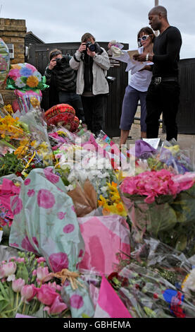 Jackiey Budden and family friend Kevin Adams (right) look at tributes left outside the home of reality TV star Jade Goody, after her death was announced at the weekend. Stock Photo