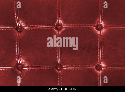 Close up of red tufter leather upholstery with buttons. Stock Photo