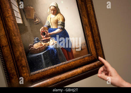 A woman points at Vermeer's painting 'The Milkmaid' during a press preview at the Metropolitan Museum of Art in New York, USA, 8 Stock Photo