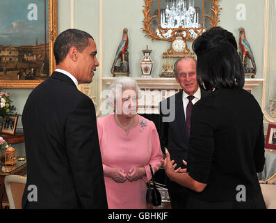 US President Barack Obama and his wife, Michelle, talk with Queen Elizabeth II and the Duke of Edinburgh during an audience at Buckingham Palace in London. Stock Photo
