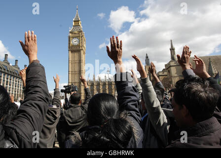 Demonstrators raise their hands during a minutes silence as they take part in a protest to call for an immediate ceasefire in Sri Lanka, at Parliament Square, Westminster, London. Stock Photo