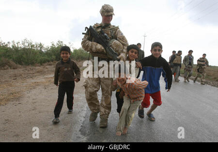 RFM Ruff from Plymouth plays with kids on Leaf Island, Basra province, in the course of an operation to hunt out insurgents who fire rockets into the camp at Basra air base. Stock Photo