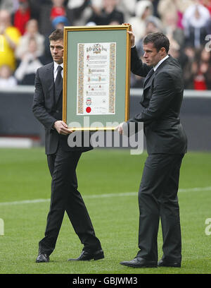 Liverpool captain Steven Gerrard (left) and defender Jamie Carragher hold the Freedom Roll of Association, which acknowledges the each of the families of those individuals who lost their lives in the Hillsborough disaster on 15 April 1989, at the official memorial service at Liverpool's Anfield Stadium, to mark the 20th anniversary of the Hillsborough disaster in which 96 football fans died. Stock Photo