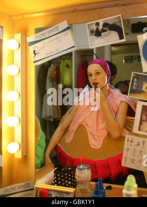 The dancer in costume as a cup cake from the London Children's Ballet applies make-up backstage before performing in the company's production of Snow White at the Peacock Theatre, London. Stock Photo