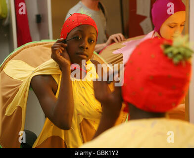The dancer in costume as a cup cake from the London Children's Ballet applies make-up backstage before performing in the company's production of Snow White at the Peacock Theatre, London. Stock Photo