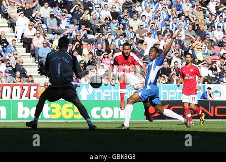 Soccer - Barclays Premier League - Wigan Athletic v Arsenal - JJB Stadium. Arsenal's Theo Walcott (centre) scores the equaliser past Wigan Athletic's goalkeeper Chris Kirkland (left) Stock Photo