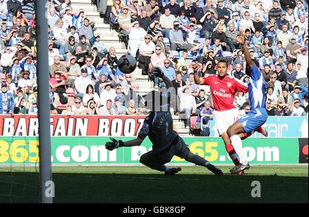 Arsenal's Theo Walcott (centre) scores the equaliser past Wigan Athletic's goalkeeper Chris Kirkland (left) Stock Photo