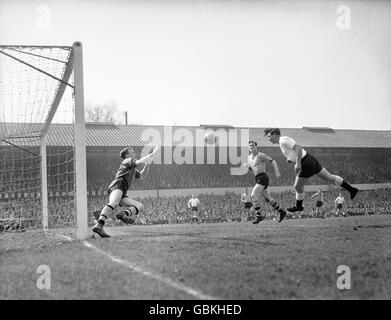 Bobbie Smith (r), of Tottenham, heads his team's first goal past Wolverhampton Wanderers's goalkeeper Malcolm Finlayson (l) at the Molineux ground. Bill Slater, the Wolves captain, is seen second from right. Stock Photo