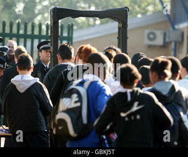 Pupils at Lammas School and Sports College in Leyton, east London, queue to pass through a metal detector at the school entrance. Stock Photo