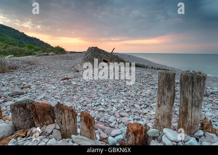 Stunning sunset over the beach at Porlock Weir in Somerset, with an old WWII bunker in the background Stock Photo