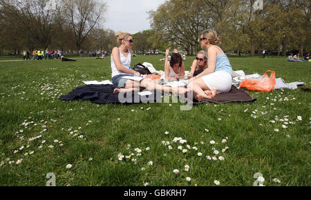 People enjoy the sunshine in Green Park, London. Stock Photo