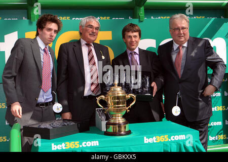 Horse Racing - bet365 Gold Cup Meeting - Day Two - Sandown Park. Trainer Carl Llewellyn (second right) celebrates winning The bet365 Gold Cup steeple chase with his horse Hennessy Stock Photo