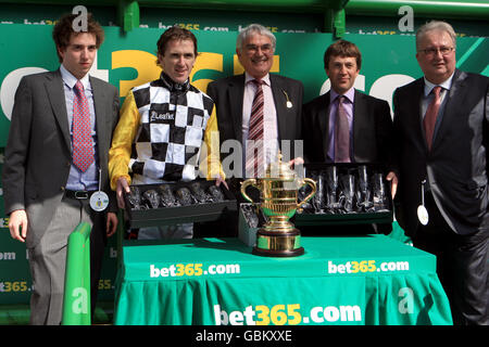 Horse Racing - bet365 Gold Cup Meeting - Day Two - Sandown Park. Jockey Tony McCoy (second left) celebrates winning The bet365 Gold Cup steeple chase on Hennessy with trainer Carl Llewellyn (second right) Stock Photo