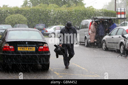 The press waiting outside Bicester Magistrates Court in, Oxfordshire, are caught in a hail storm.