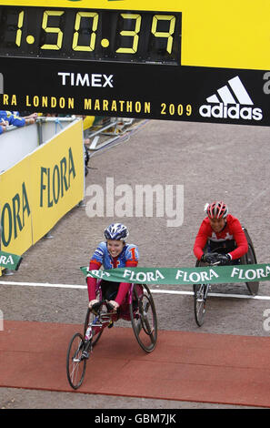 Switzerland's Edith Hunkeler crosses the finish line to win the women's wheelchair race followed by Austraila's Christie Dawes, second, during the 2009 Flora London Marathon, London. Stock Photo