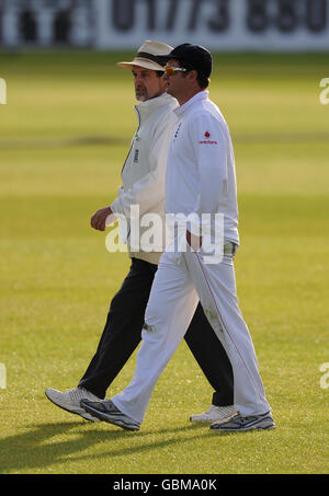 England Lions captain Robert Key (right) chats with umpire Peter Willey as they leave the field of play at the end of the day during the Tour Match at the County Ground, Derby. Stock Photo