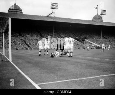 Referee F Coultas (third r) checks on the condition of Aston Villa's Peter McParland (third l) after he collided with Manchester United goalkeeper Ray Wood (fourth l) as United's Roger Byrne (l), Jackie Blanchflower (second l), Duncan Edwards (second r) and Bill Foulkes (r) look on worriedly Stock Photo