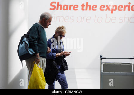 A couple using a smart phone, Keflavik International Airport, Keflavik, Iceland Stock Photo