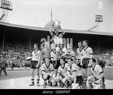 Wolverhampton Wanderers captain Bill Slater holds the FA Cup aloft as he is chaired by his jubilant teammates: (back row, l-r) Gerry Harris, Malcolm Finlayson, Ron Flowers, Peter Broadbent, Eddie Clamp, George Showell; (front row, l-r) Barry Stobart, Des Horne, Jimmy Murray, Norman Deeley Stock Photo