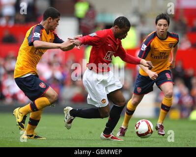 Manchester United's Patrice Evra (centre) battles for the ball with Arsenal's Samir Nasri (right) and Neves Denilson (left) Stock Photo