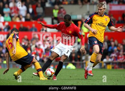 Manchester United's Patrice Evra (centre) battles for the ball with Arsenal's Nicklas Bendtner (right) and Neves Denilson (left) Stock Photo