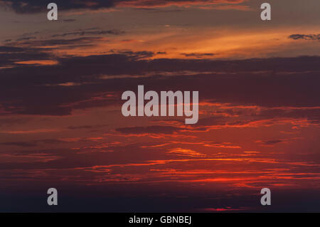 Red tinted clouds during the sunset in the summer Stock Photo
